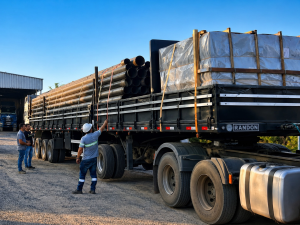 Equipe acompanhando a conferência e a fixação de tubos e materiais antes do início do transporte.